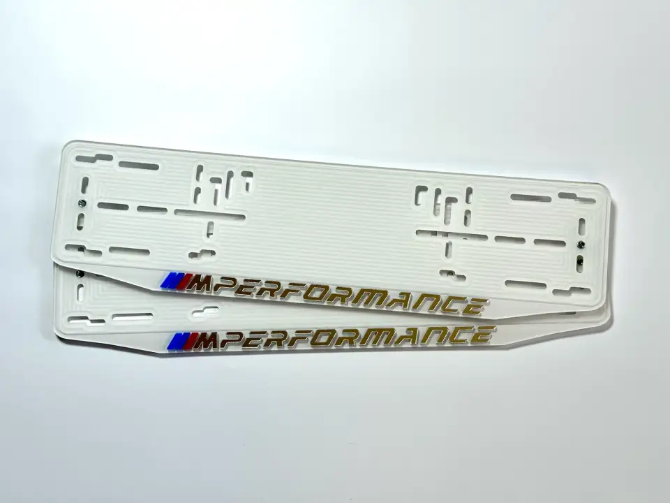 BMW M Performance · белая рамка, золотые буквы Белая номерная рамка BMW M Performance с золотыми буквами и M-полосками