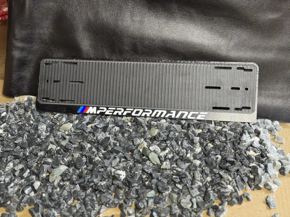 BMW M Performance · чёрная рамка целиком Чёрная номерная рамка BMW M Performance с белыми буквами, общий план