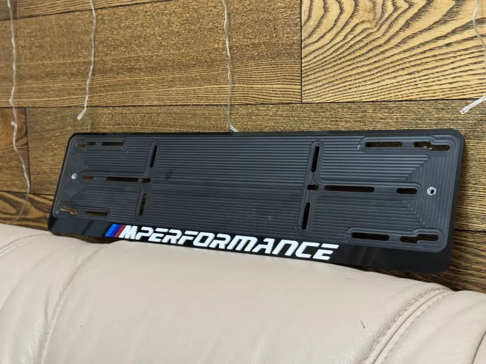BMW M Performance · чёрная рамка, белые буквы Чёрная номерная рамка BMW M Performance с белыми объёмными буквами и M-полосками