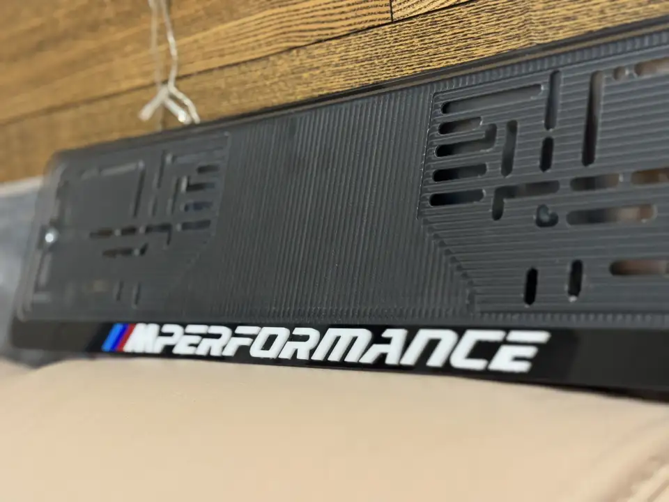 BMW M Performance · белые буквы, макро Крупный план надписи M Performance на чёрной номерной рамке