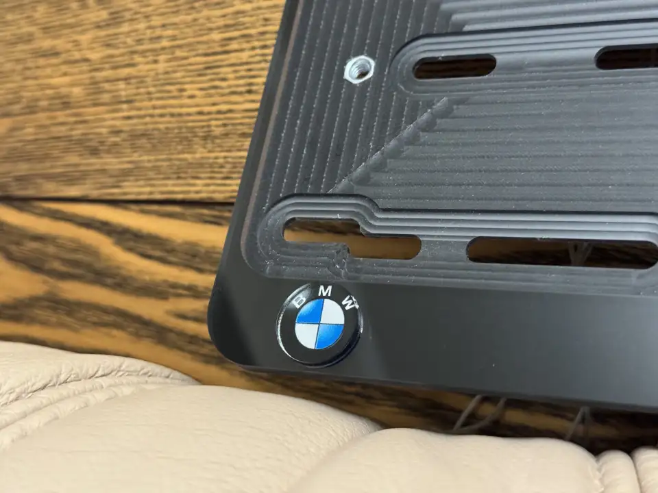 BMW · эмблема крупным планом Крупный план чёрной номерной рамки BMW с эмблемой в углу