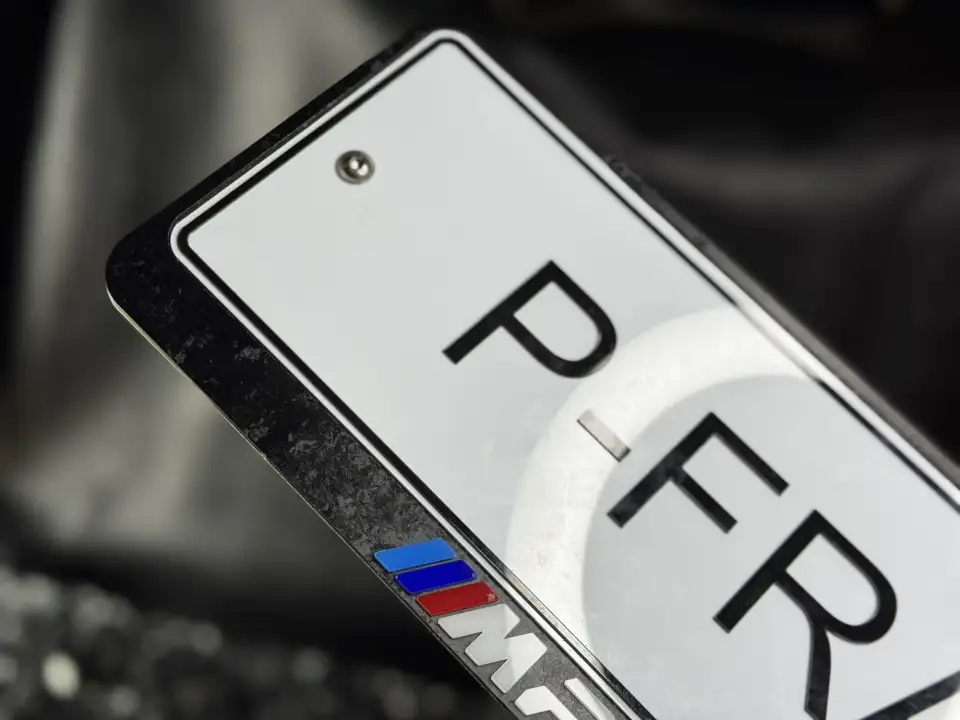 BMW M Performance · карбон, макро Макро угла карбоновой номерной рамки BMW M Performance с логотипом