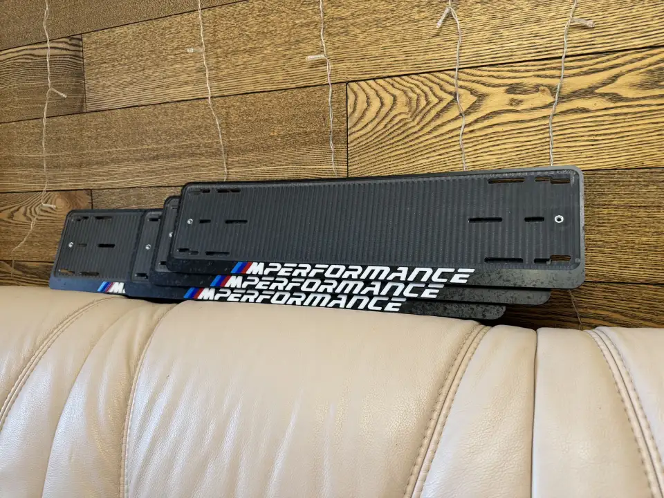 BMW M Performance · чёрный карбон, белые буквы Чёрная карбоновая номерная рамка BMW M Performance с белыми буквами и M-полосками