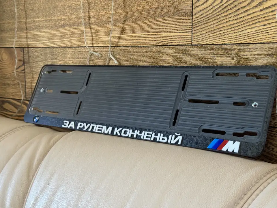 BMW M · «За рулем конченый», мрамор Чёрная номерная рамка BMW M с надписью «За рулем конченый» и мраморной вставкой