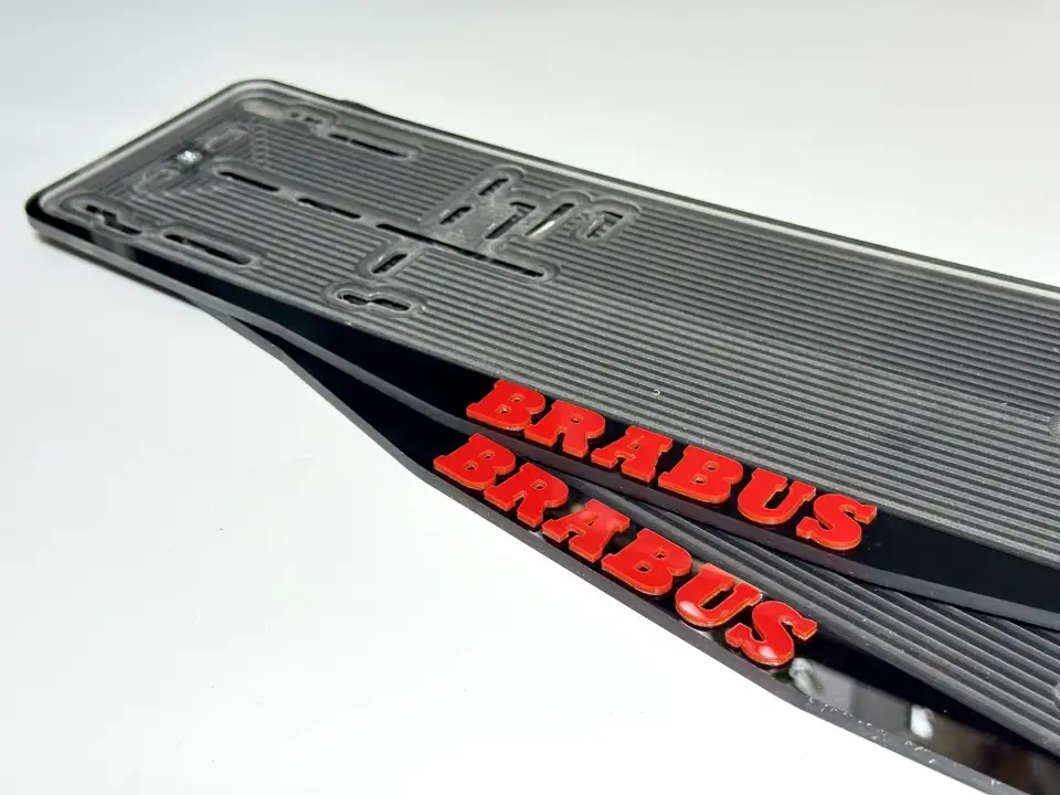 BRABUS · крупный план красных букв Крупный план красных объёмных букв BRABUS на чёрной номерной рамке