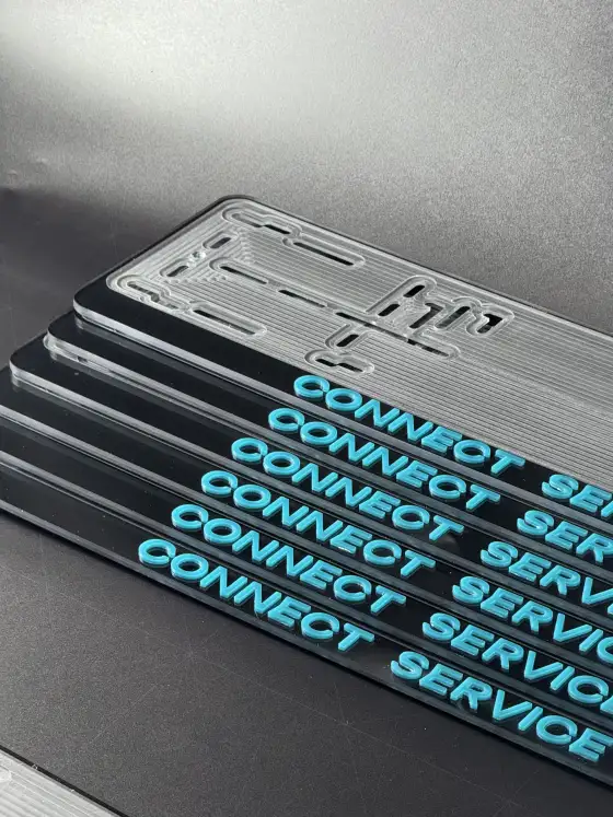 Несколько чёрных номерных рамок CONNECT SERVICE с бирюзовыми объёмными буквами