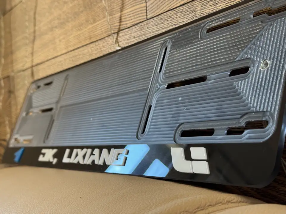 OK, Lixiang · под углом Номерная рамка OK, Lixiang с логотипом Li крупным планом под углом