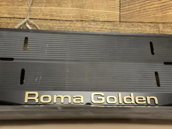 Roma Golden · золотые буквы, макро Крупный план золотой надписи Roma Golden на чёрной номерной рамке