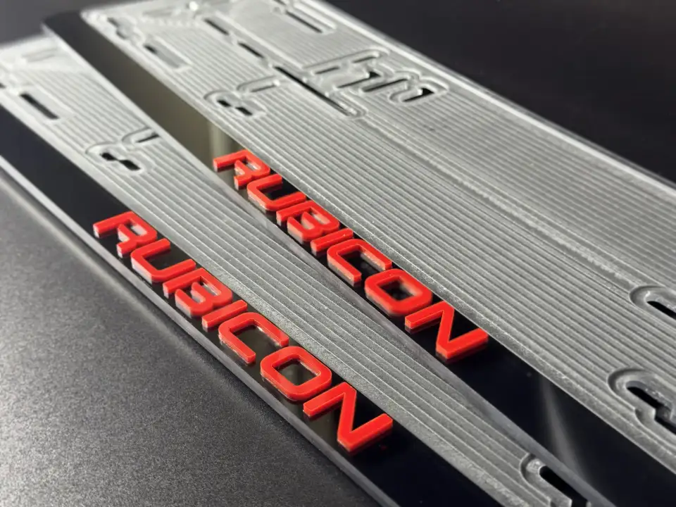RUBICON · крупный план красных букв Крупный план красных объёмных букв RUBICON на чёрной номерной рамке