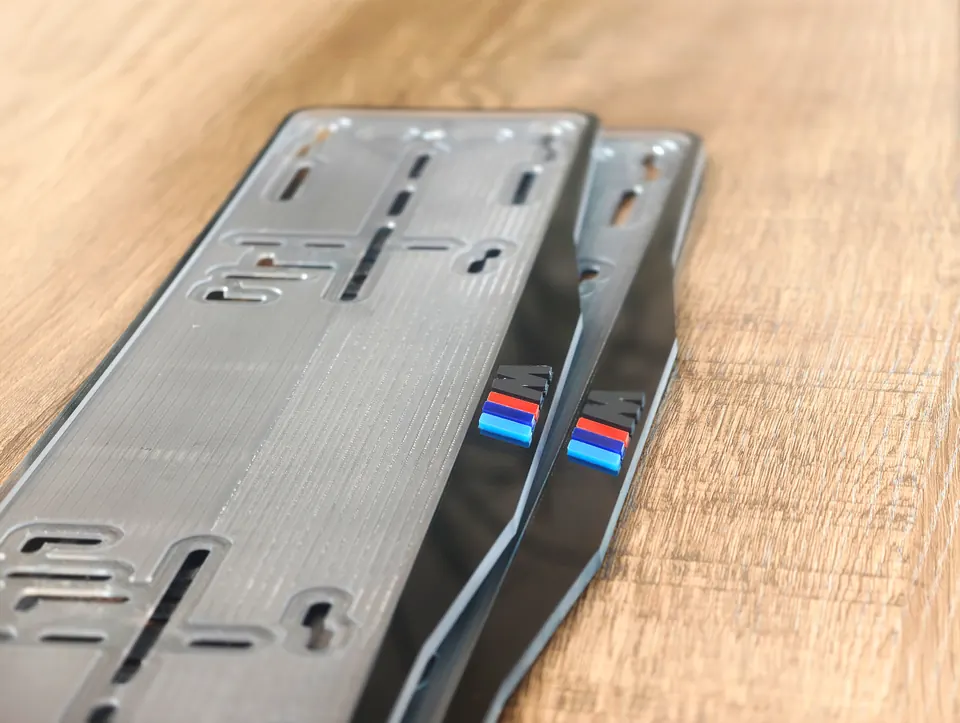 «M» · BMW · чёрный глянец, разноцветные буквы Номерная рамка BMW с надписью «M», цвет рамки - чёрный глянец, разноцветные объёмные буквы